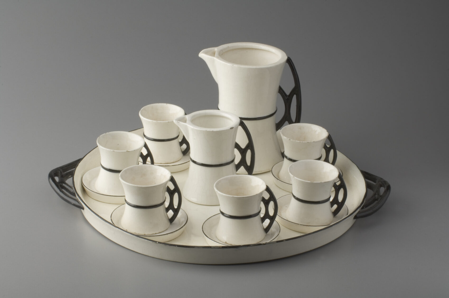 Kávová souprava na tácu , šálky, konvice, mléčenka z bílé keramiky s úzkým černým proužkěm