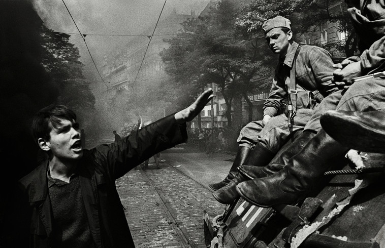 Muž křičí na sovětské vojáky sedící na tanku